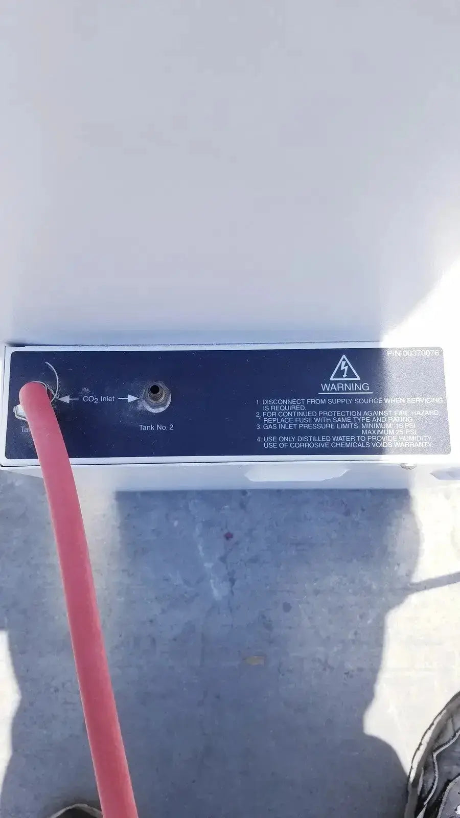Black rectangular warning label with white text on white surface of fisher scientific co2 incubator 116885h back side
