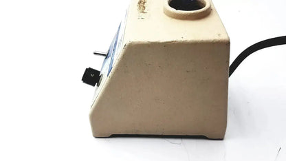 Beige plastic base of fisher scientific vortex genie 2 vortexer with black power switch and circular top opening