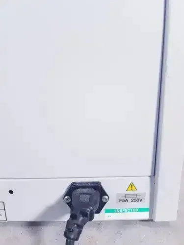 Black power cord plugged into white fisher scientific isotemp hybridization rotisserie incubator back with fsa 250v label