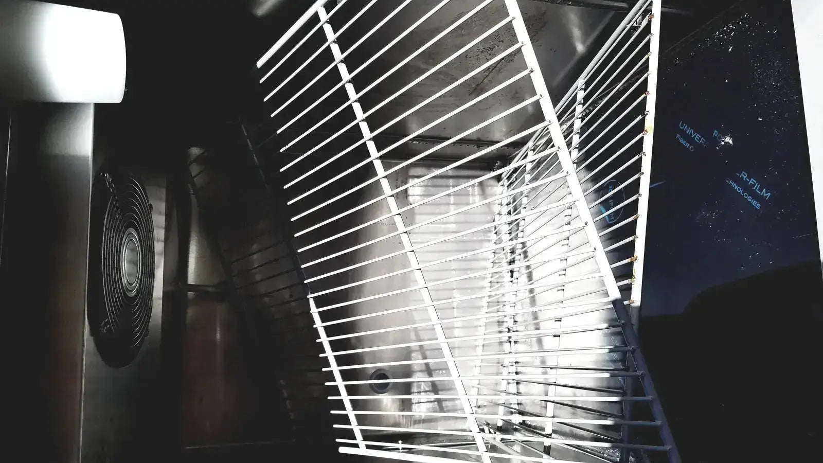White metal rack with parallel bars inside fisher scientific isotemp laboratory freezer refrigerator for organized storage