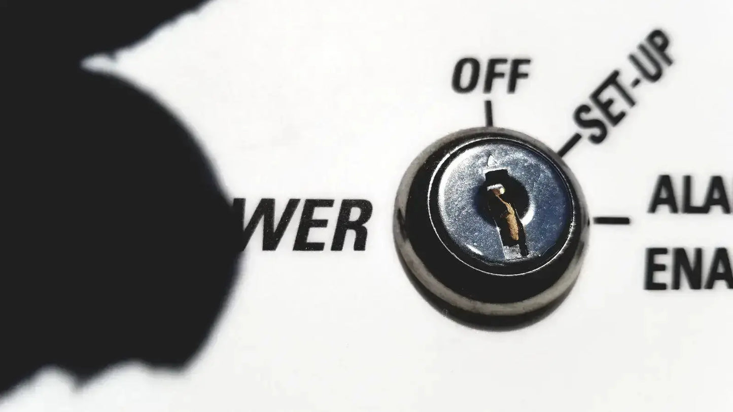 A metallic keyhole with a golden key inserted in the silver circular lock of a Fisher Scientific isotemp laboratory freezer refrigerator