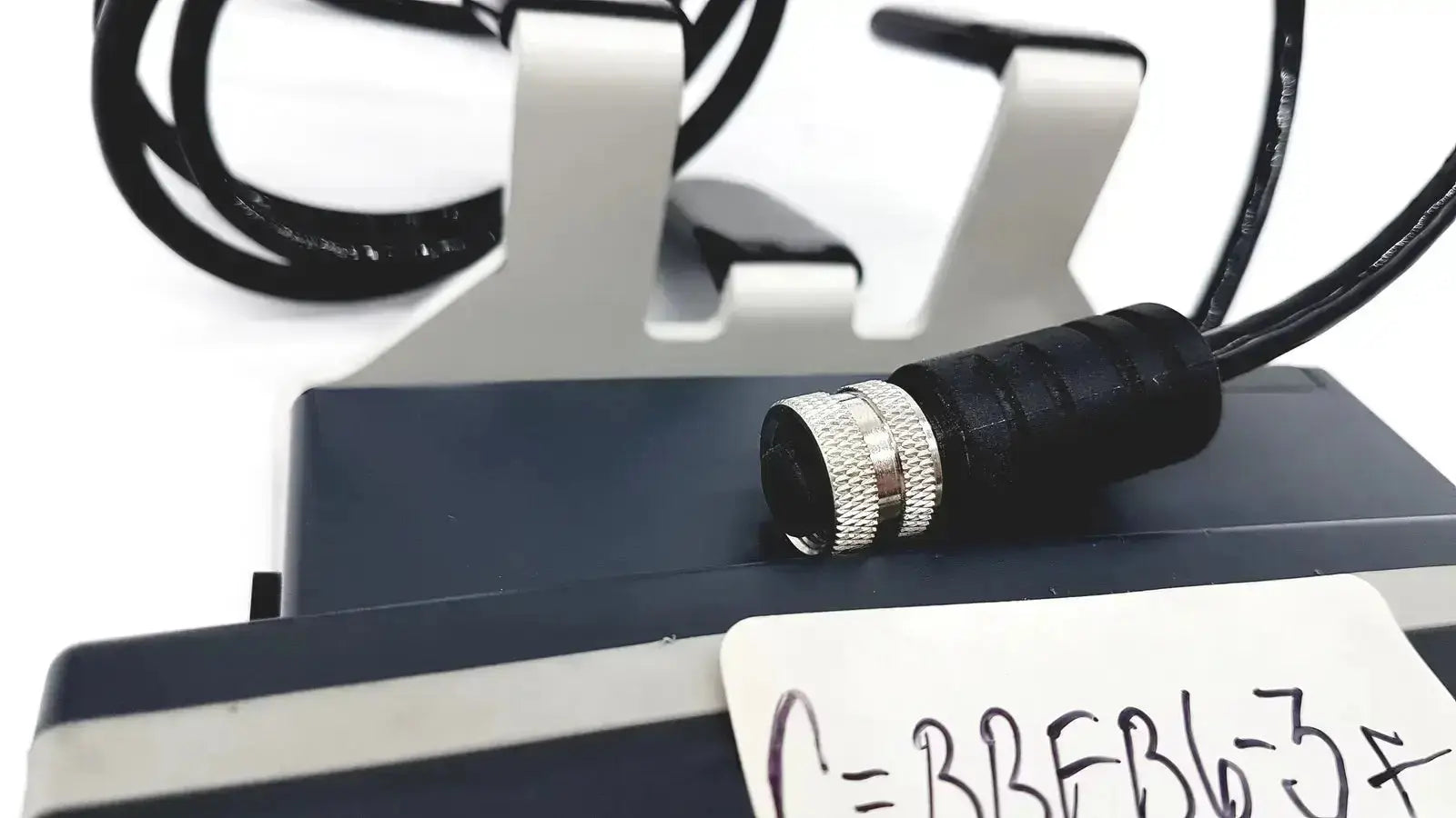 Black and silver threaded connector with black cable on dark gray equipment fits med-mizer allcare beds