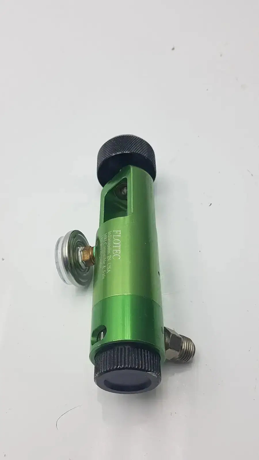 Green metallic flotec mri compatible oxygen regulator with black knurled caps and silver fittings for safe use