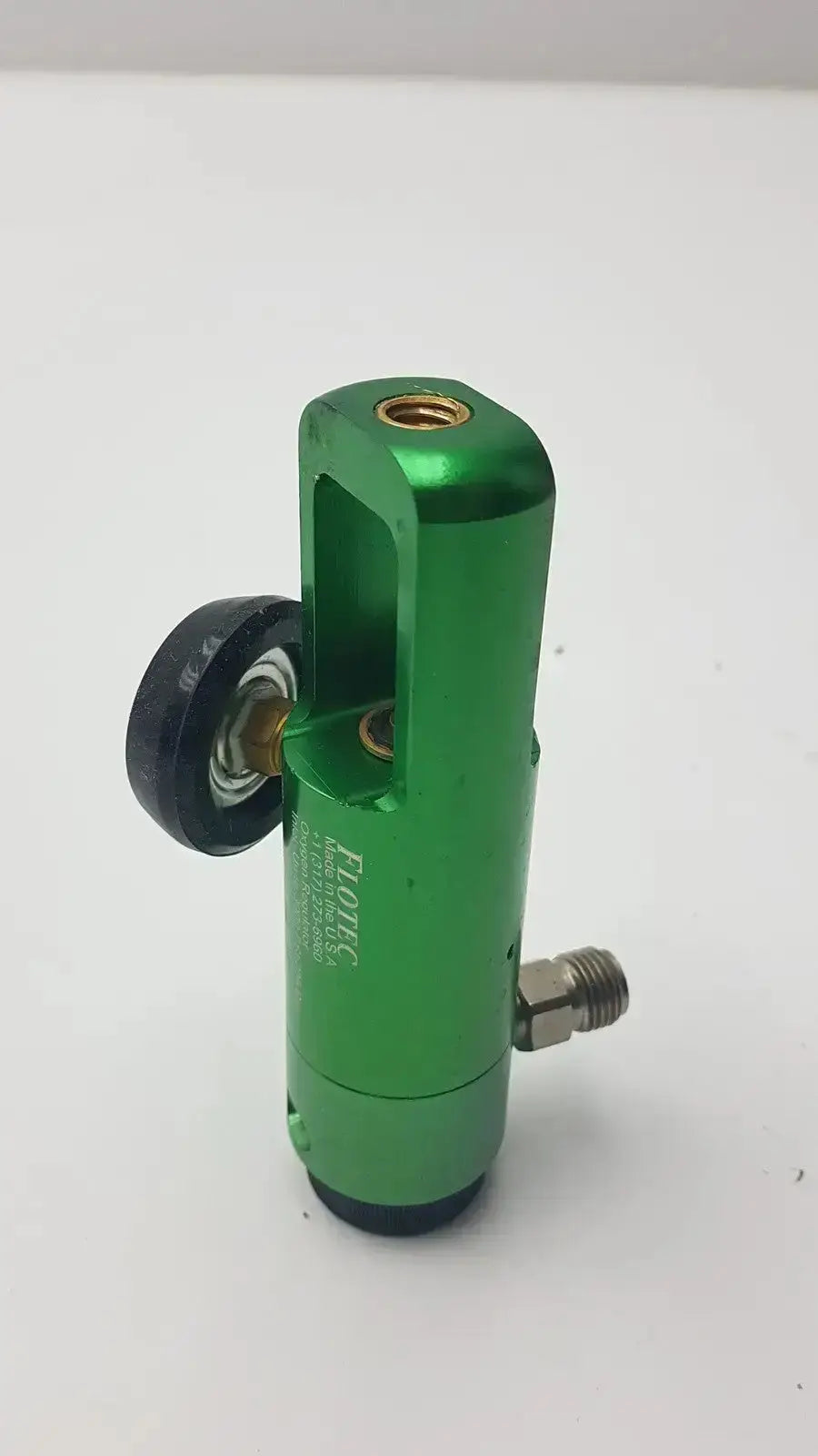 Green metallic flotec oxygen regulator with black wheel and brass fittings for medical equipment up to 3000 psi