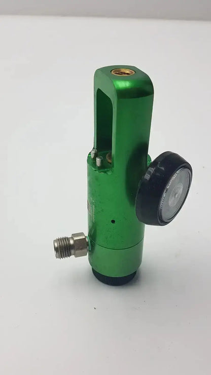 Green metallic flotec oxygen regulator with black pressure gauge and threaded fittings for medical equipment use