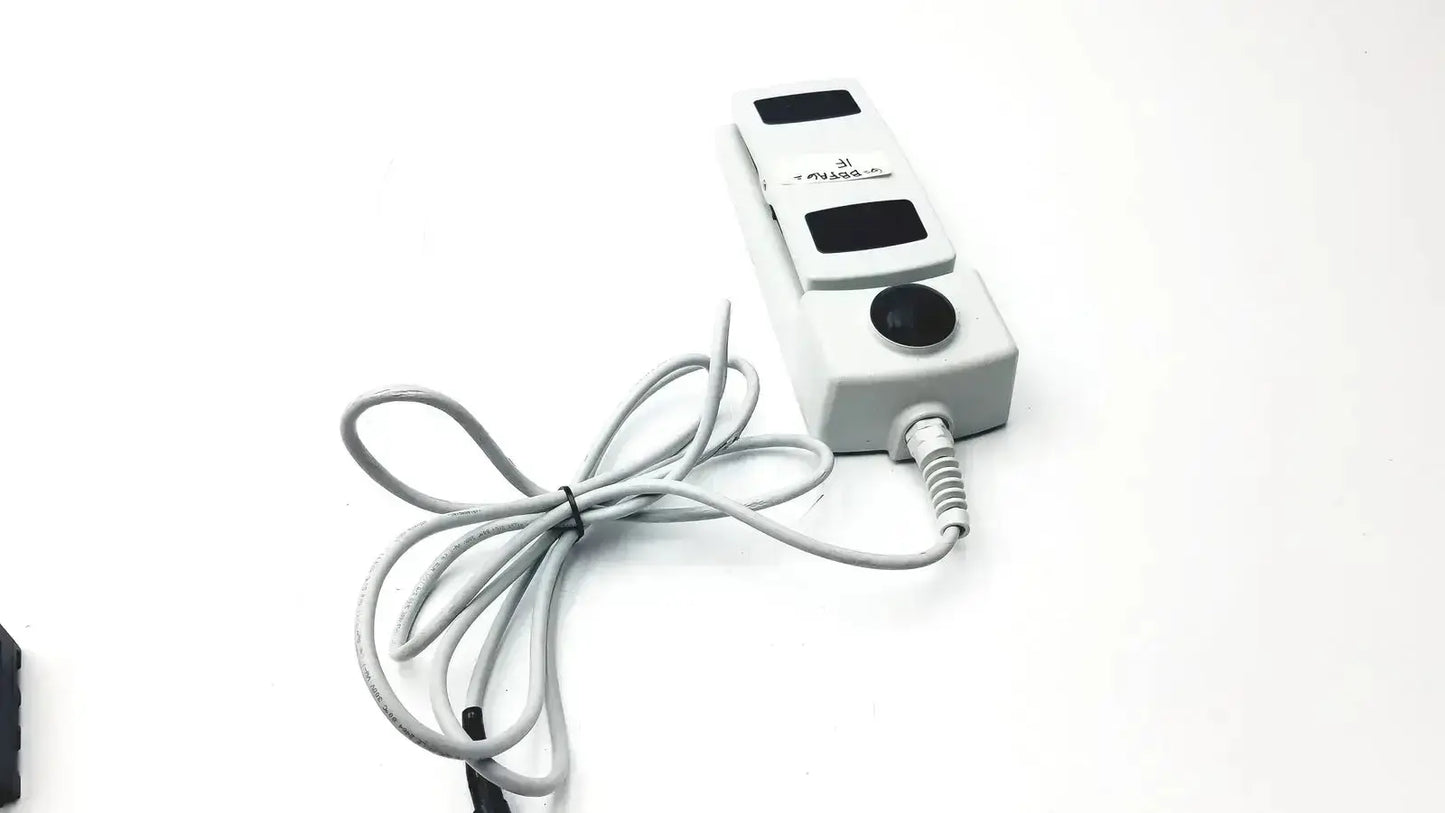 White plastic footswitch w7102106 with three black rectangular buttons, circular button, and power cable for medical use