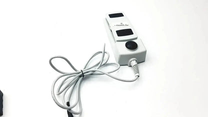 White plastic footswitch w7102106 with three black rectangular buttons, circular button, and power cable for medical use