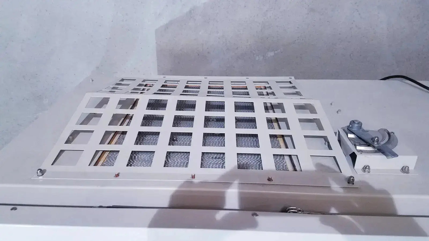 White metal grid panel with square openings and mesh inserts secured by screws on the back of forma scientific biological safety cabinet