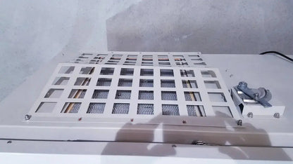 White metal grid panel with square openings and mesh inserts secured by screws on the back of forma scientific biological safety cabinet