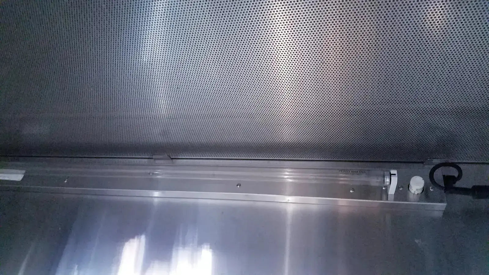Silver perforated metal panel with reflective surface and circular holes on forma scientific biological safety cabinet
