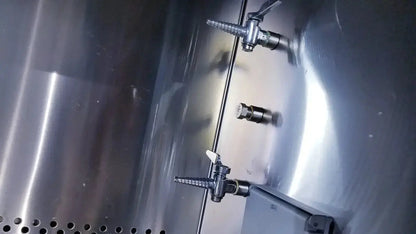 Stainless steel beverage dispenser with three spigots and perforated base in a Forma Scientific biological safety cabinet