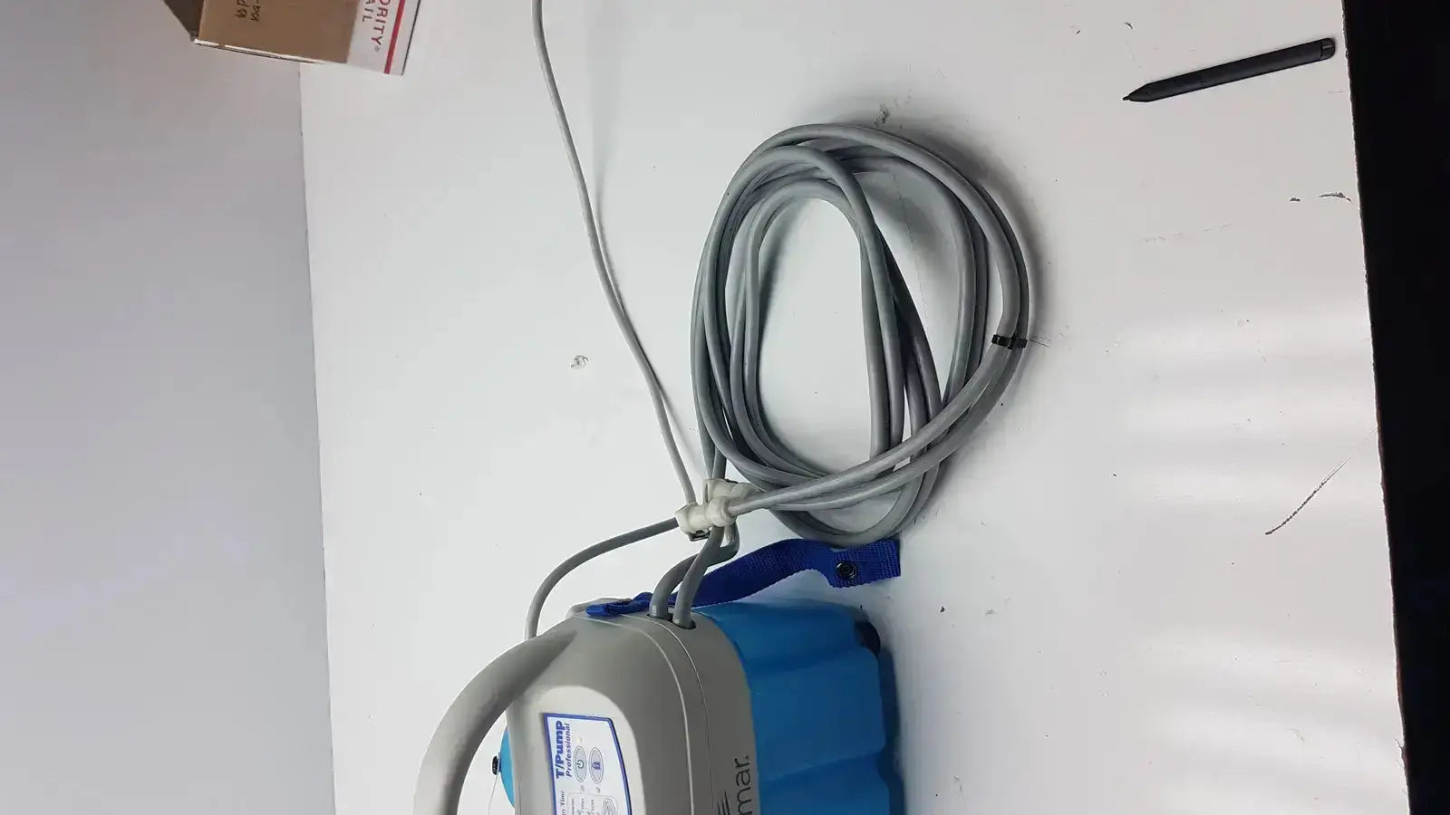 Blue and gray handheld Gaymar T Pump professional heat therapy pump TP700C with coiled cord for heat therapy use