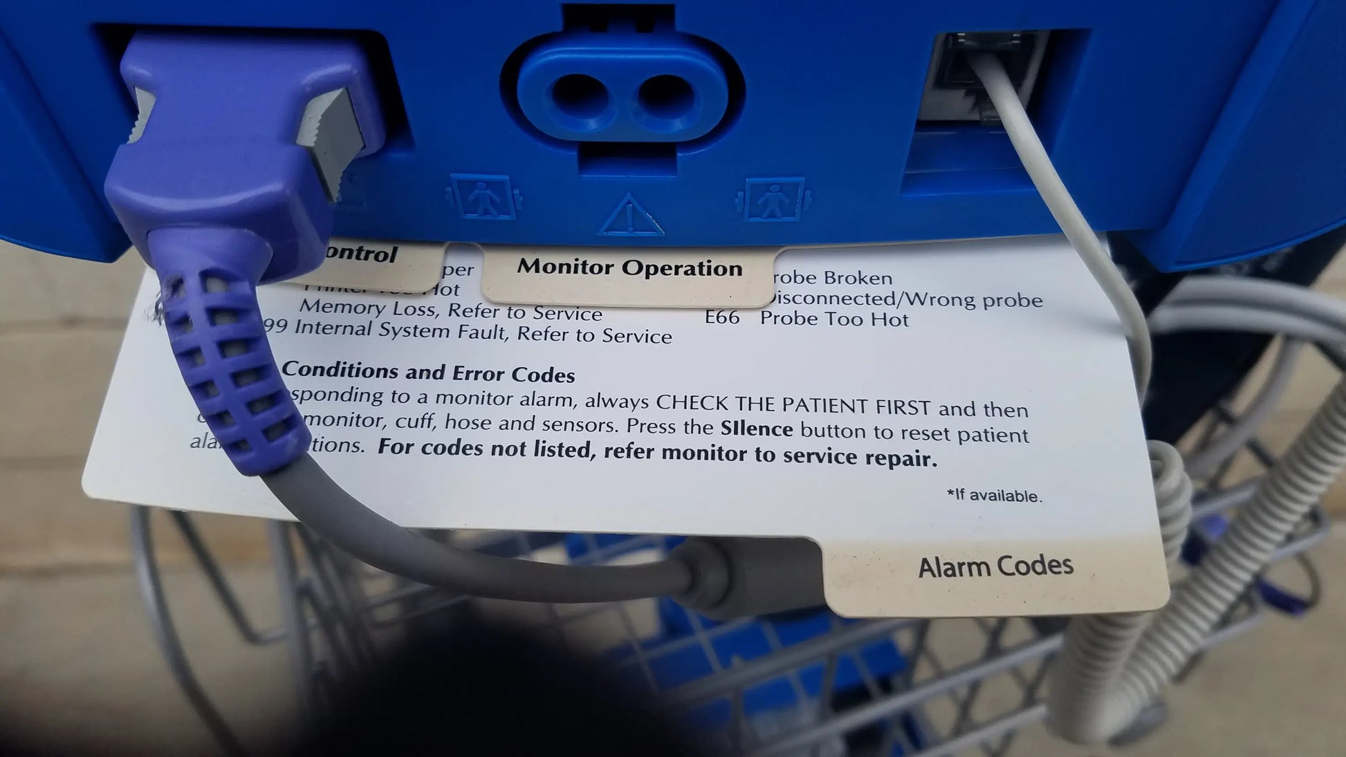 Blue medical monitor cable with textured plastic connector plugged into blue dinamap procare dpc 400 medical equipment