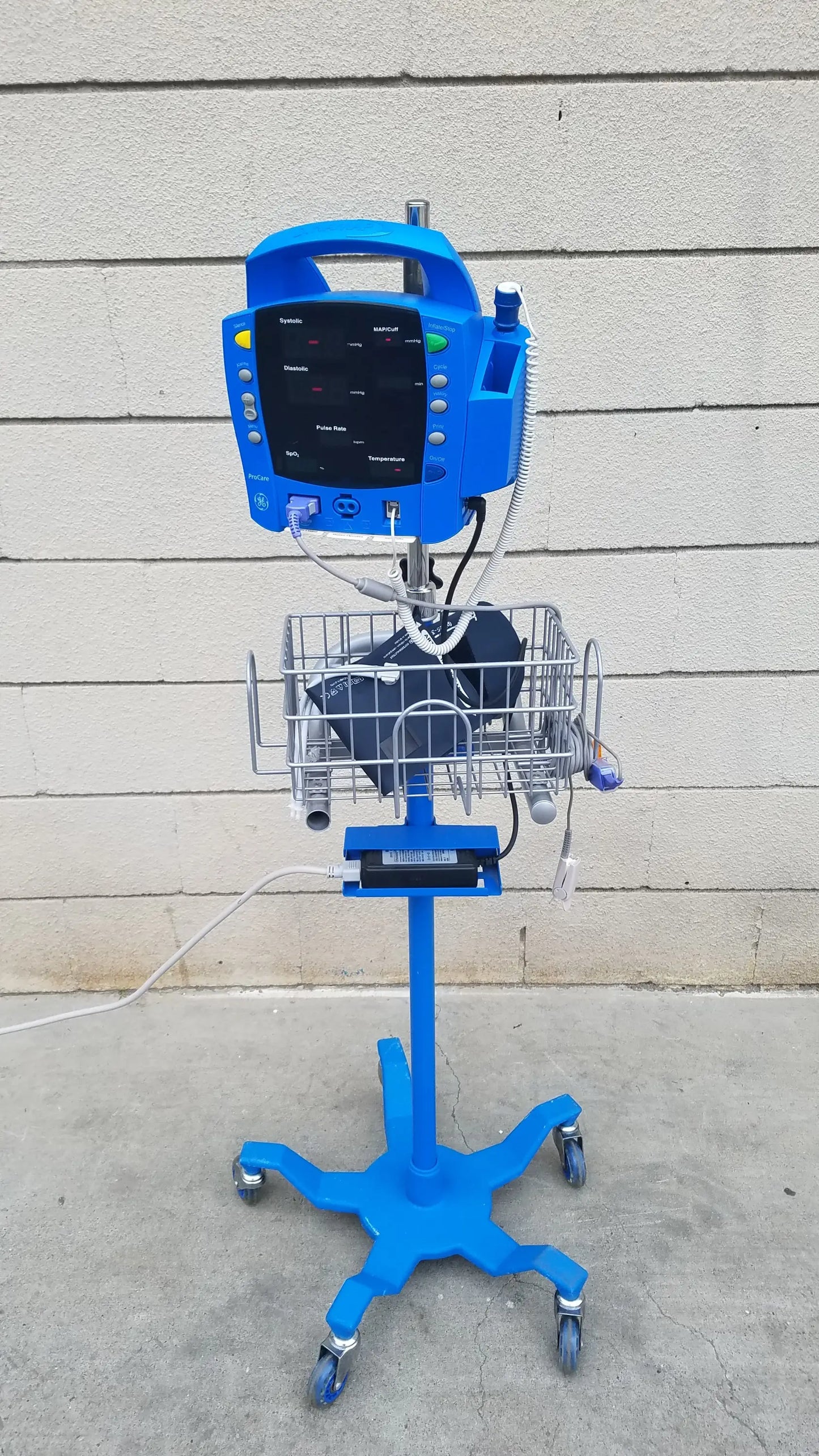 Blue GE Dinamap ProCare DPC 400 vital signs medical monitor on wheeled cart with wire basket for reuse medical equipment