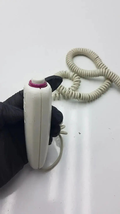White plastic dragonfly hand switch with magenta button cap and coiled beige cable for precise control use