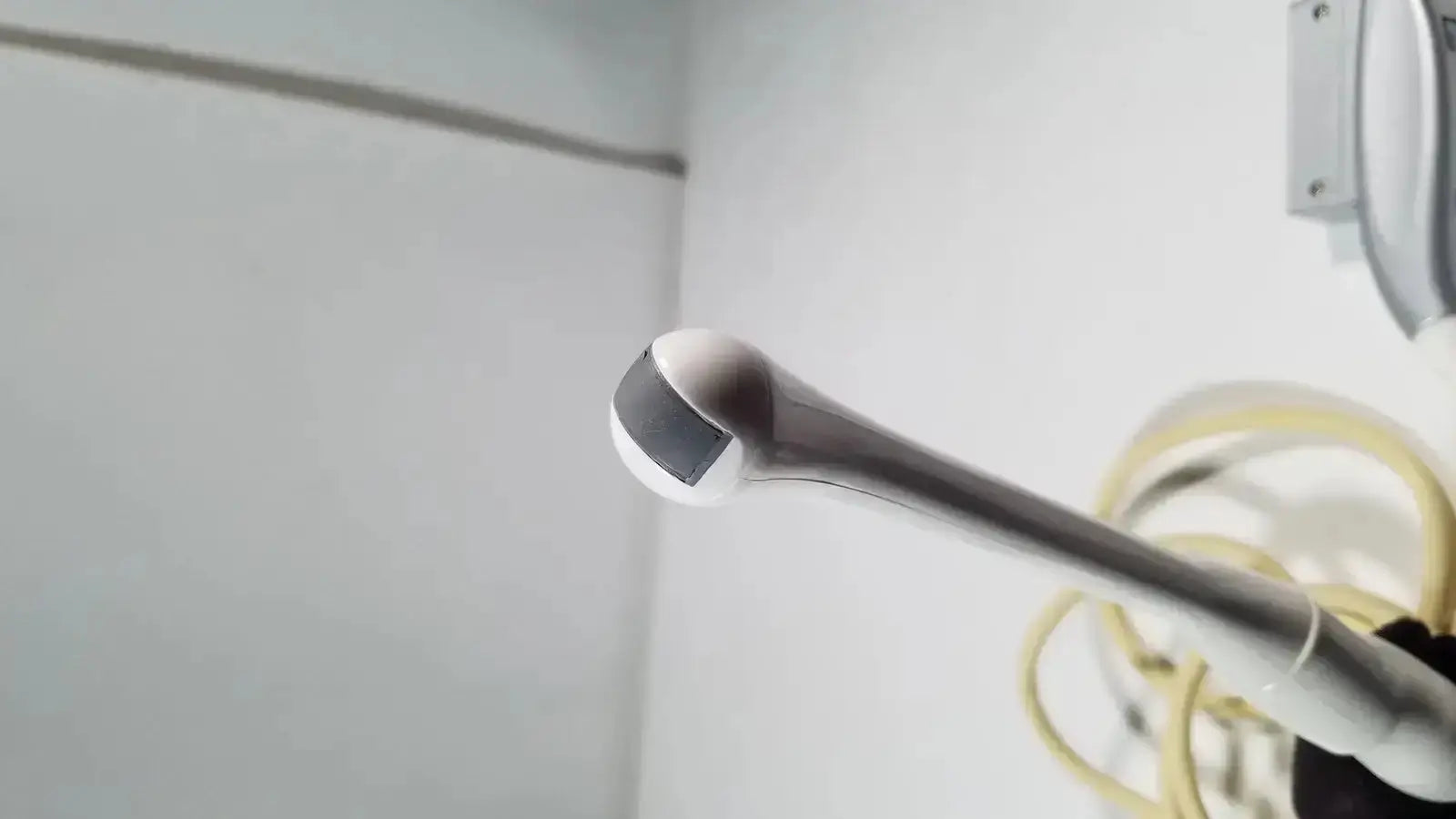 Silver metallic e8c-rs endovaginal ultrasound probe with rounded black-tipped head for endovaginal ultrasound use