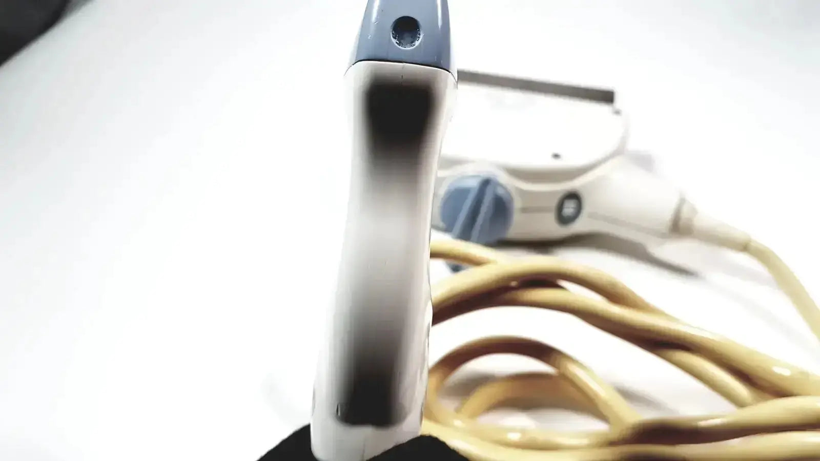 White and gray electric hair straightener with coiled beige power cord for healthcare 11l linear array ultrasound use