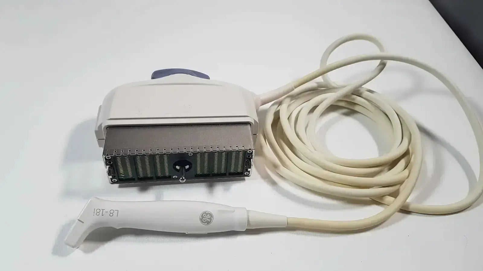 White ge l8-18i-d linear array ultrasound transducer with coiled cable and beige housing for array ultrasound use