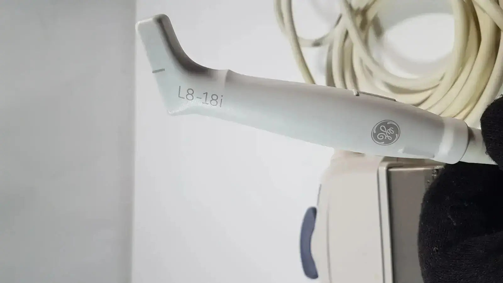 White ge l8-18i-d linear array ultrasound transducer with ergonomic design and smooth plastic finish for medical imaging