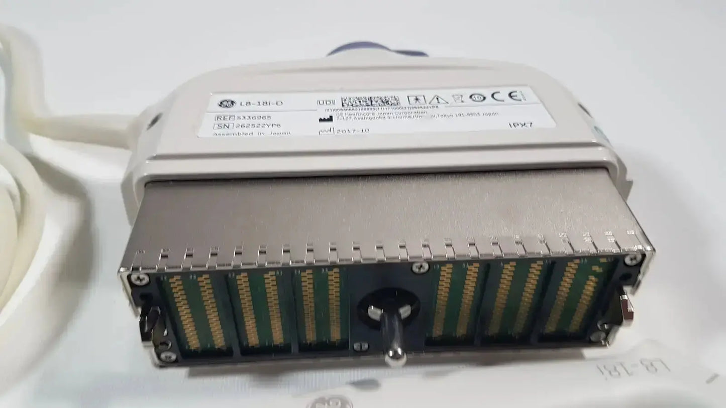 Gray metallic industrial connector with gold-plated pins and rotary knob on ge l8-18i-d linear array ultrasound device