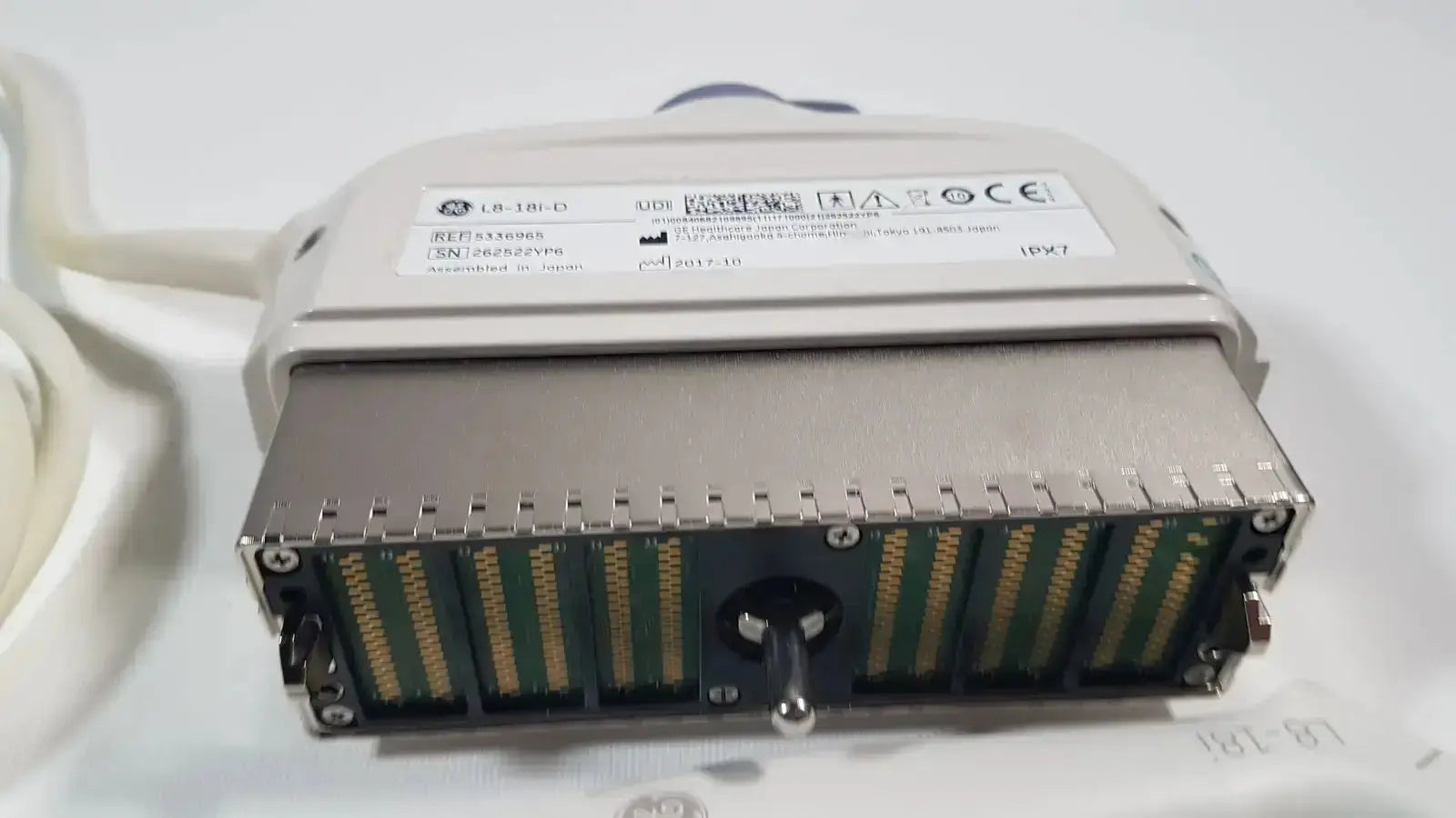 Gray metallic industrial connector with gold-plated pins and rotary knob on ge l8-18i-d linear array ultrasound device