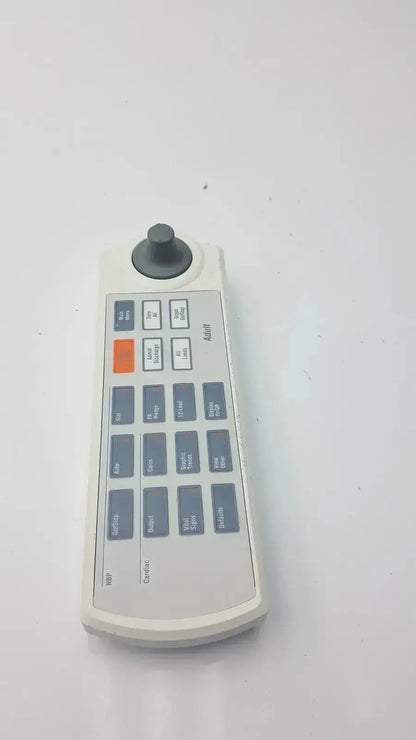White plastic remote keypad for marquette solar 8000m-8000i with black joystick gray buttons and an orange button