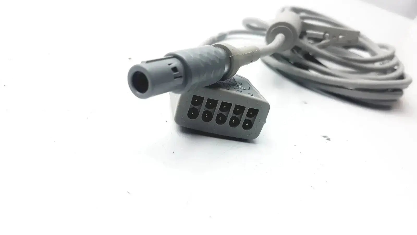 Gray ge medical ecg trunk cable r2424549 with coiled cord and connector featuring multiple black pins for reliable use