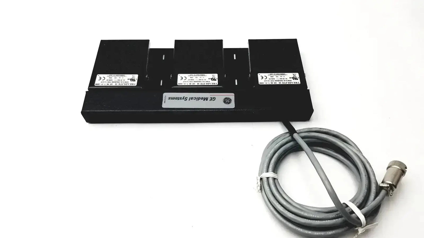 Black ge medical systems battery charger with three slots and coiled gray power cable for systems footswitch use