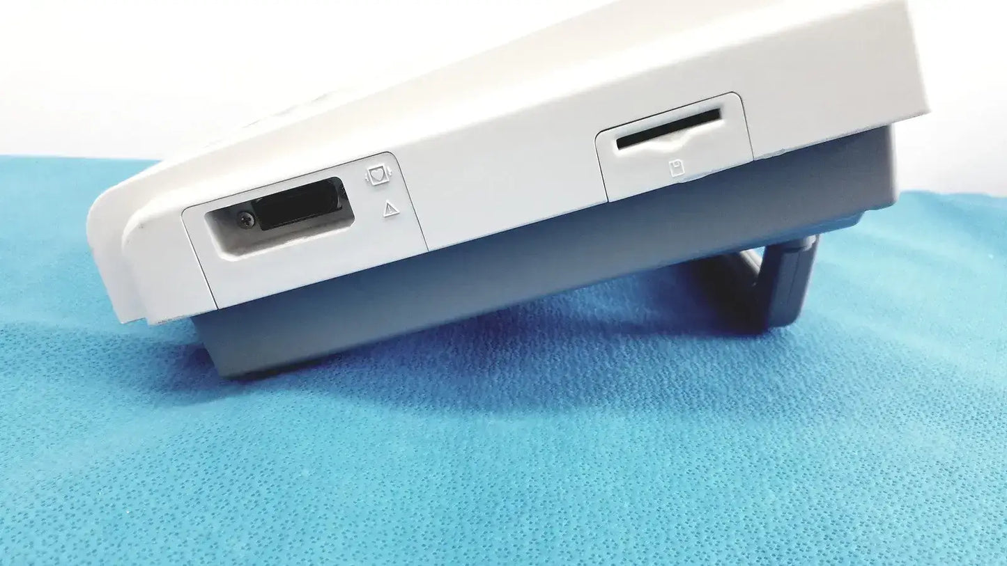White nintendo switch console with gray base and visible ports shown with ge medical systems mac 800 ecg machine