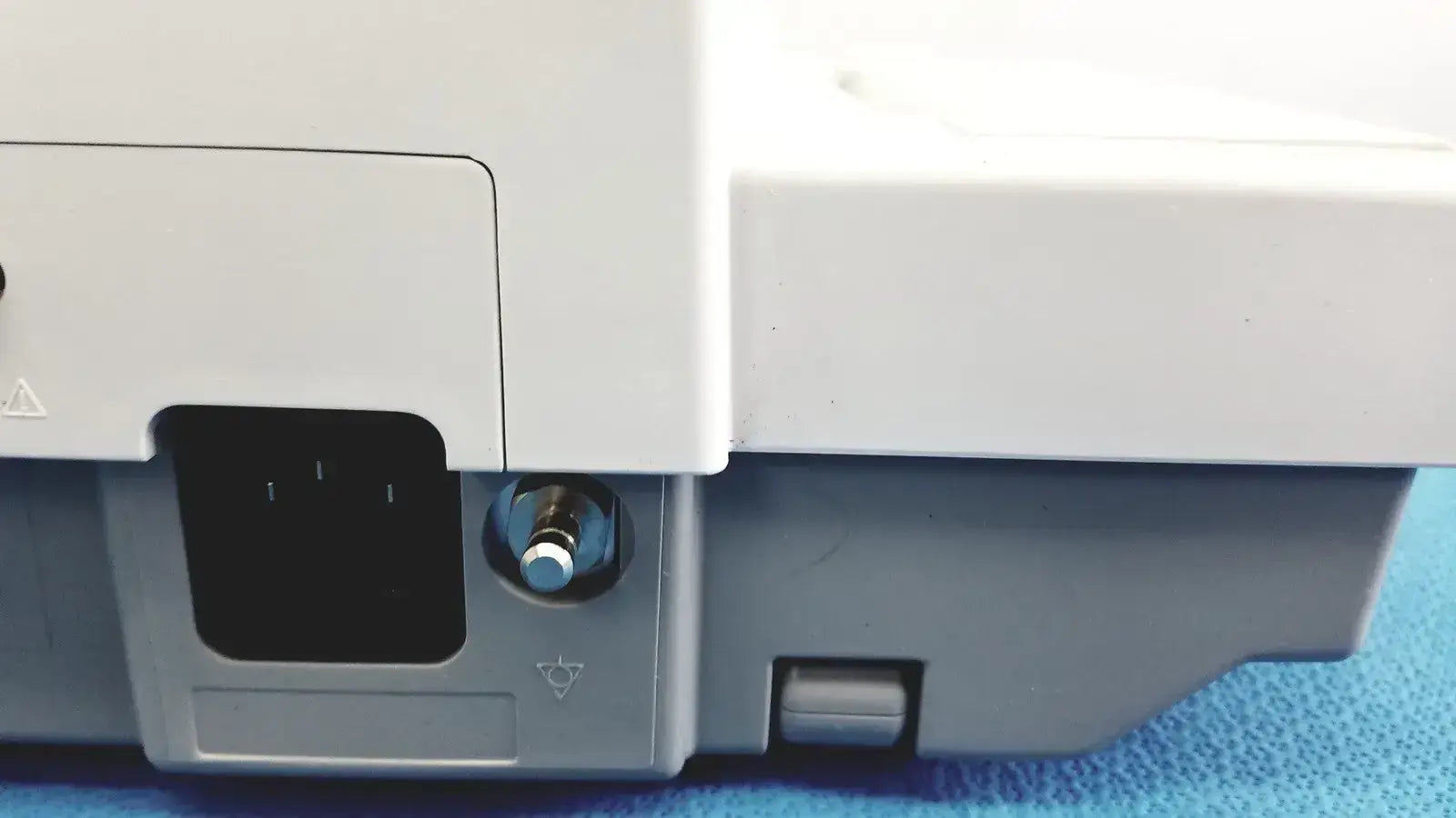 White and gray plastic base of ge medical systems mac 800 ecg machine with metallic power button on the front side