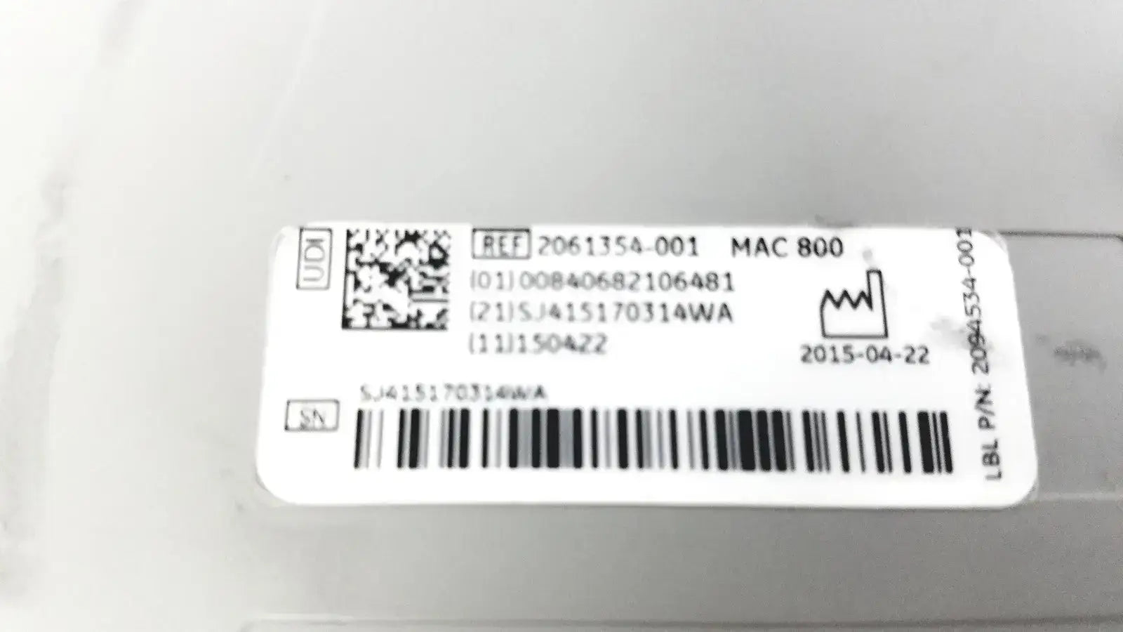 White rectangular label with black text barcode qr code and serial numbers on the back of ge medical systems mac 800 ecg machine