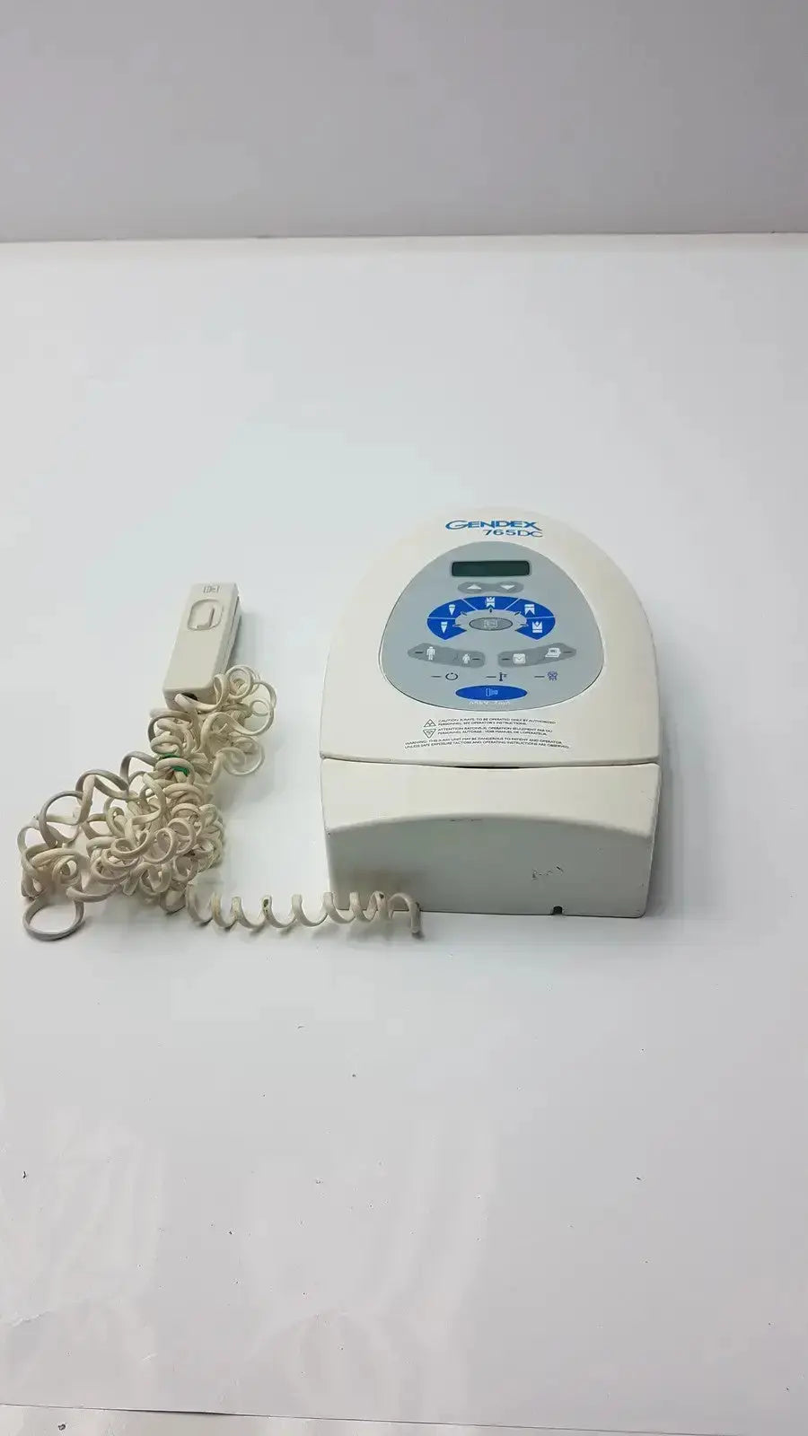 Cream-colored Gendex 765DC Xray remote control panel with blue-lit control panel and coiled cord for precise remote control