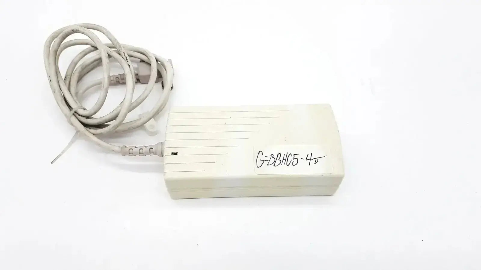 Beige plastic spacelabs snp-a085-3y power adapter with coiled gray cable and handwritten label for used medical equipment sale