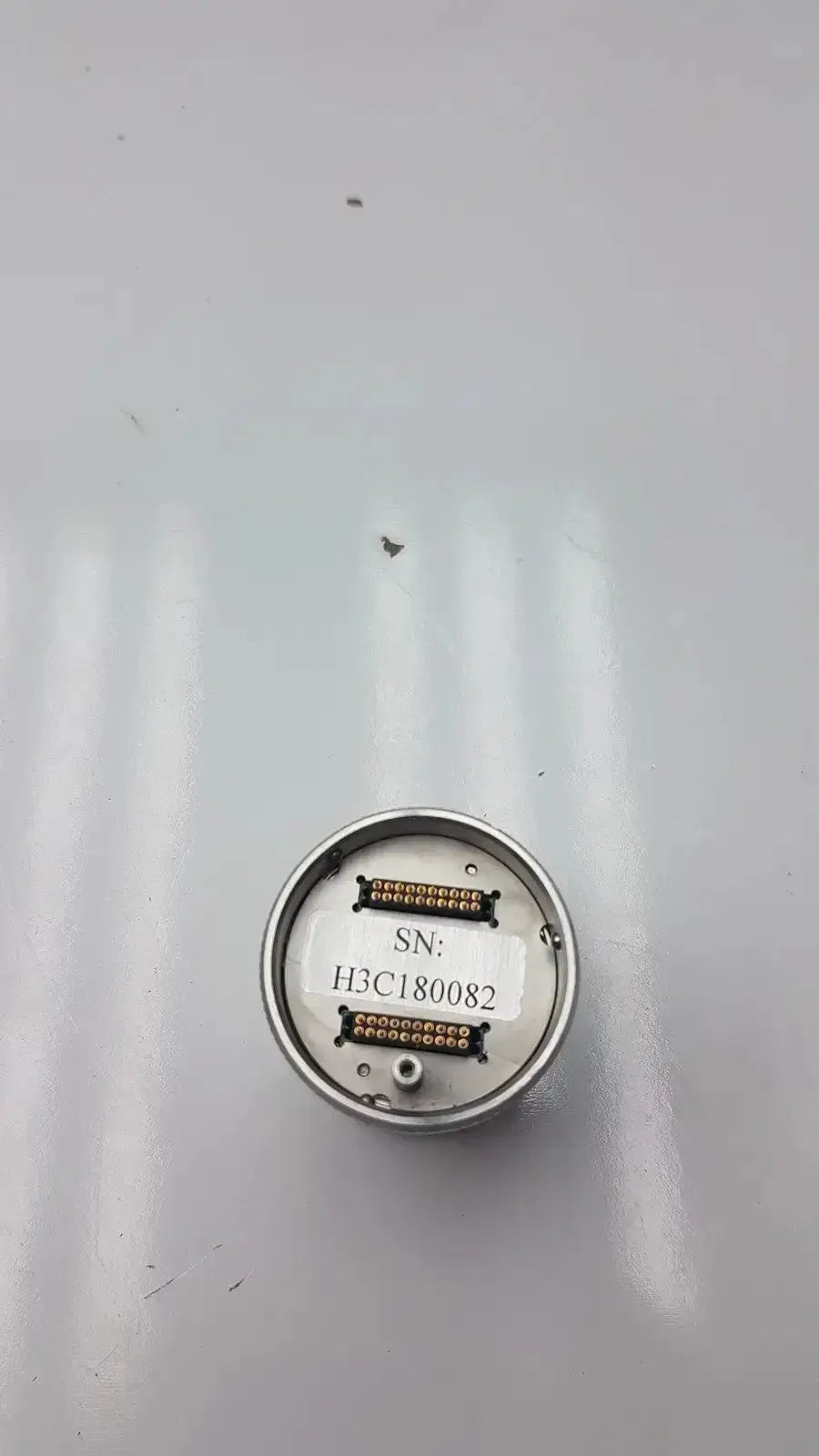 Circular metallic sensor with silver casing and serial number h3c180082 on the back of globalmed total exam ke018257 hd 1080p camera