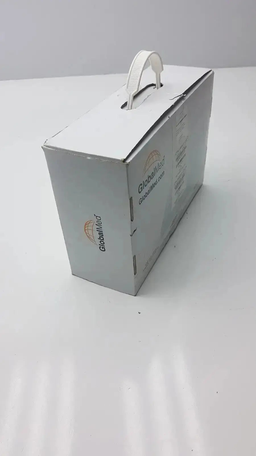 Silver-colored cardboard box with a white handle and globalmed branding for total exam ke018257 hd 1080p camera
