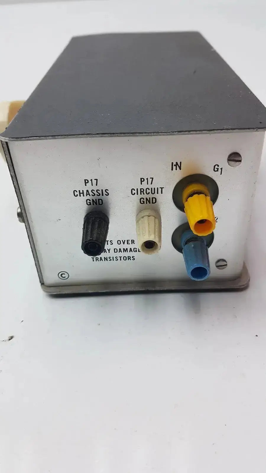 Gray metal electronic signal conditioning box with labeled input output connectors and color coded plugs on back of grass instrument amplifier model p17b