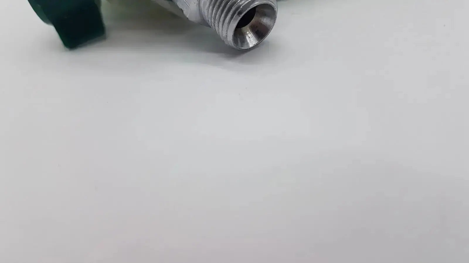 Silver metallic pipe fitting with threaded end and green plastic handle for green suction pump water hose use