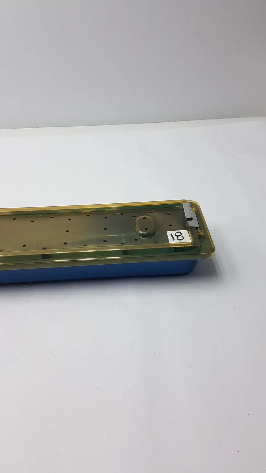 Blue plastic gyrus mra-gt slimline sterilization tray with translucent yellow lid and perforated interior for reuse medical equipment