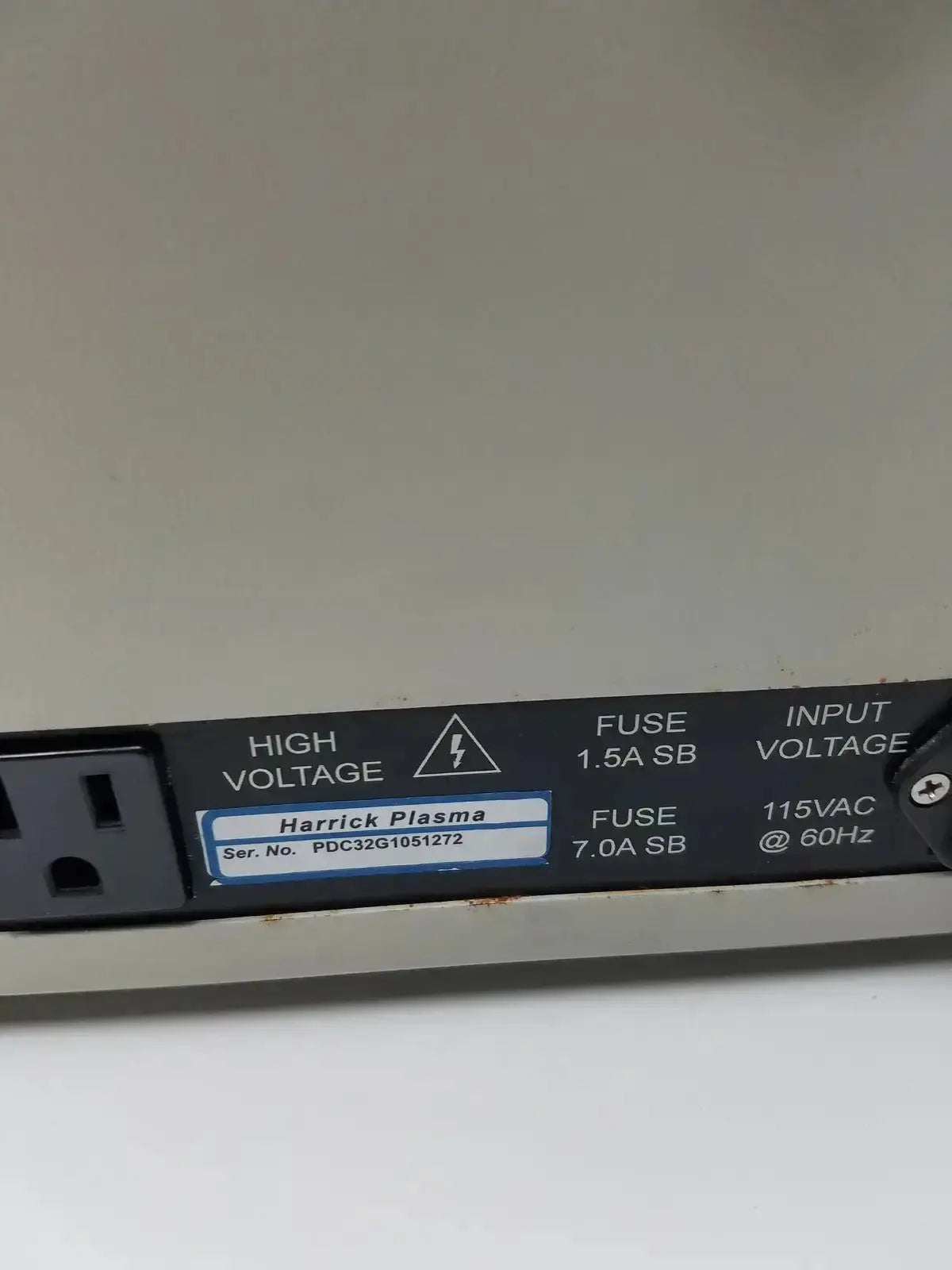 Black rectangular label with white text and blue-bordered harrick plasma sticker on the back of a plasma cleaner sterilizer unit