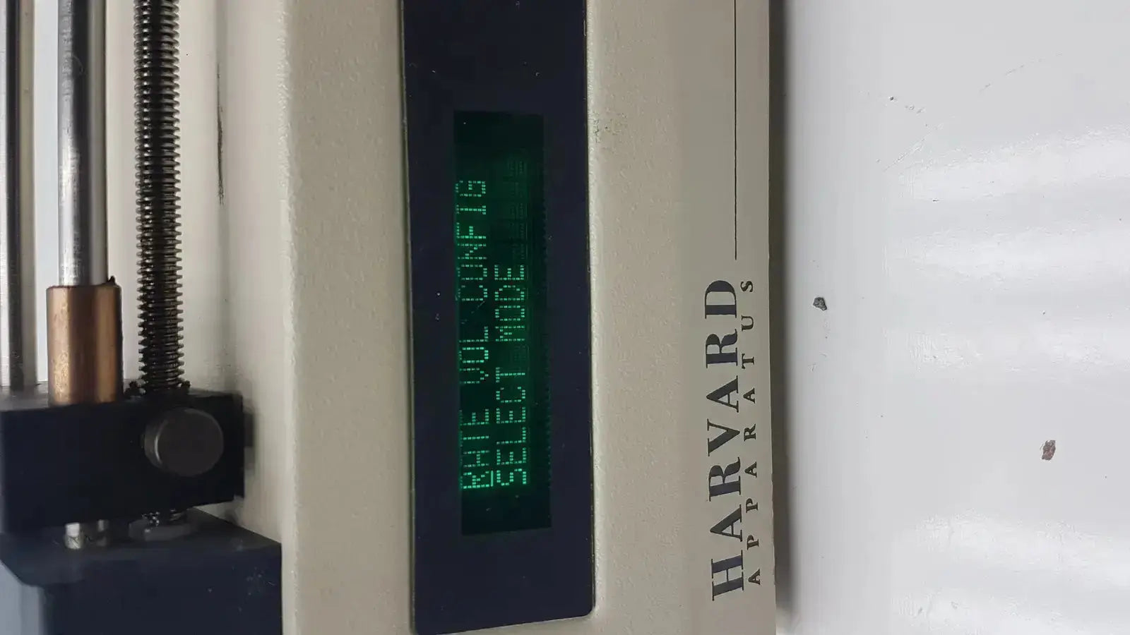 Harvard apparatus model 11 digital single syringe pump with metallic components and green lcd screen displaying rate vol config select mode