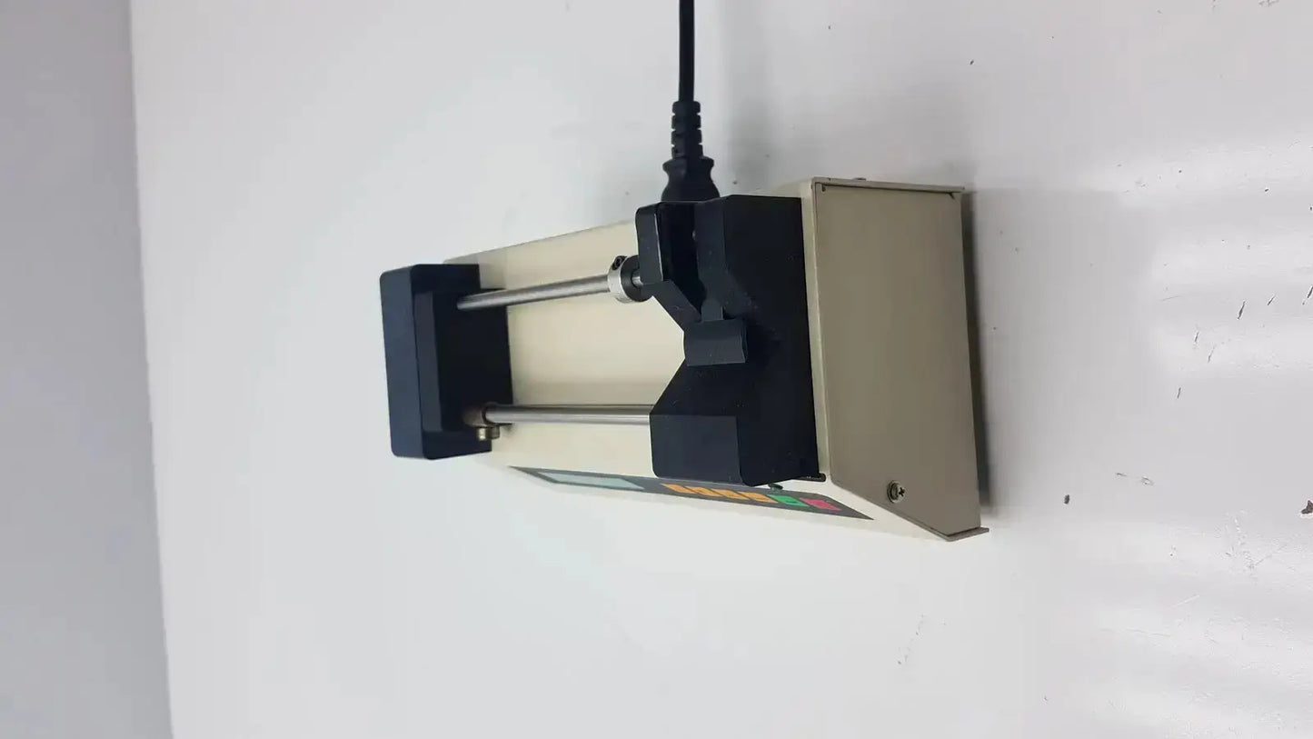 Black and beige Harvard Apparatus Model 11 digital single syringe pump with digital display mounted on a wall