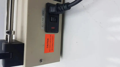 Beige industrial-grade power strip with black switch and medical caution label on the back of harvard apparatus model 11 digital single syringe pump