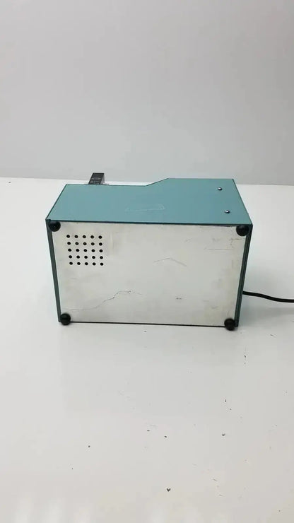 Image of the back side of a teal and silver harvard apparatus rodent ventilator model 683 with perforated panel and power cord