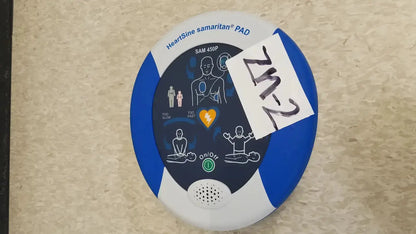 Blue and white heartsine samaritan pad 450p automated external defibrillator with instructional diagrams on the front panel
