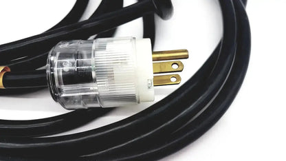Black heavy-duty extension cord with clear plastic white insulated lead single phase plug and gold-colored prongs hospital grade