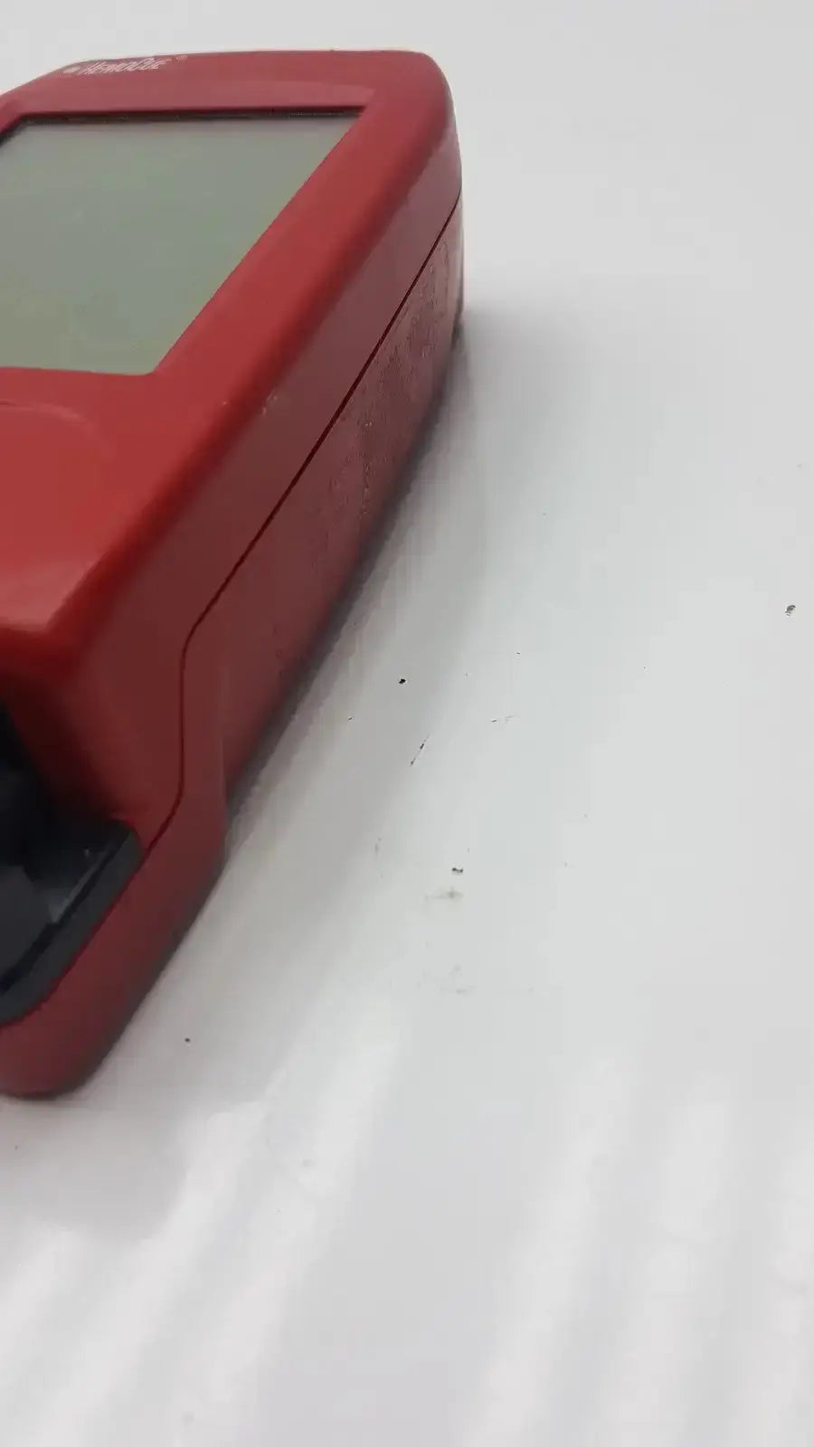 Red plastic handheld hemoCue Hb 201 dm hemoglobin system analyzer with rectangular screen and black port for biomedical evaluation