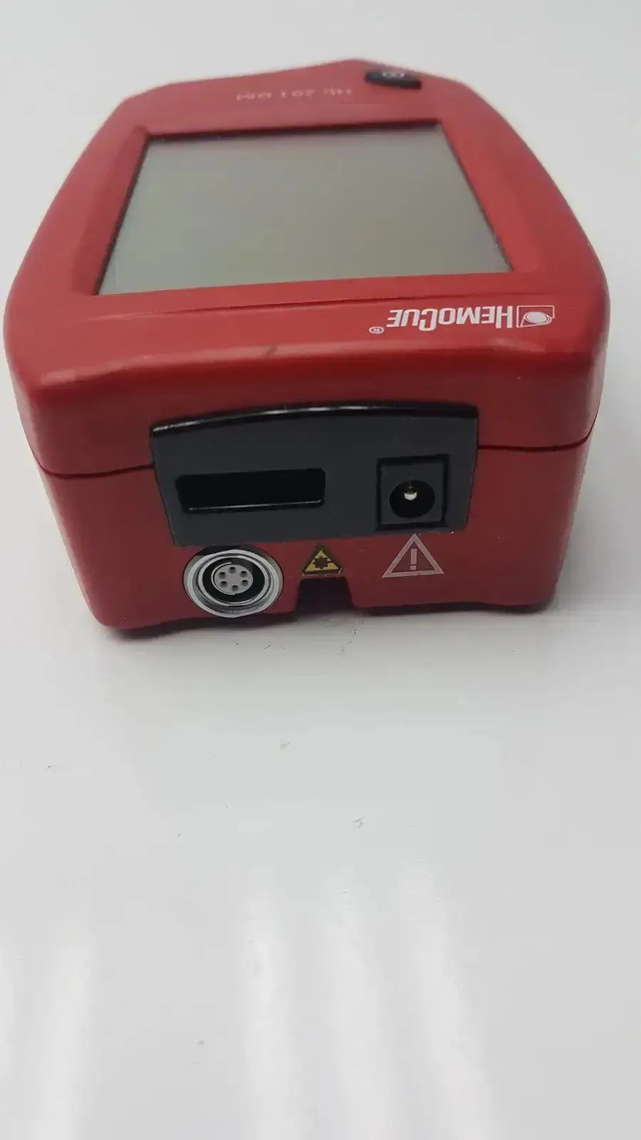 Red hemocue handheld blood glucose analyzer with square screen and black ports for biomedical evaluation and hospital surplus reuse medical