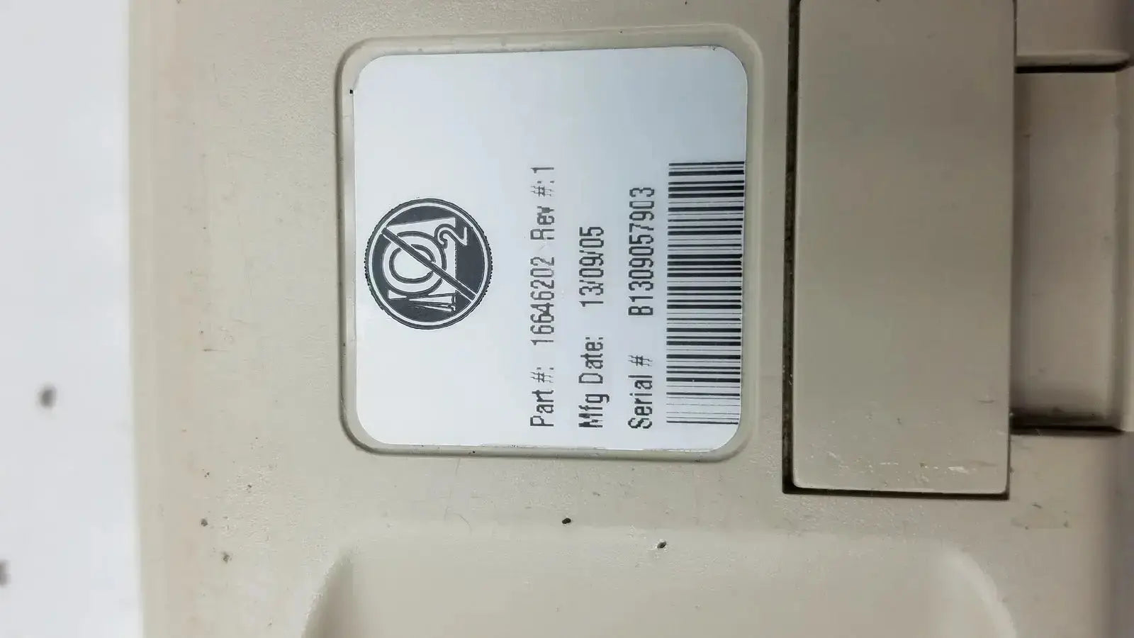 Beige plastic hill-rom patient hand control for bed with white label showing part number manufacturing date and serial number
