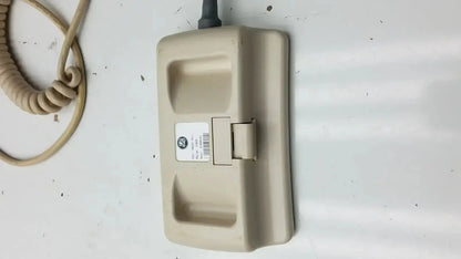 Beige plastic hill-rom patient hand control for bed 16646202 with coiled cord and small label for hospital use
