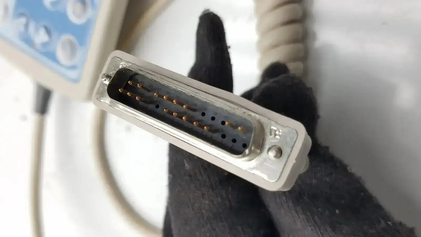Gray plastic d-sub connector with metallic pins and screw on the back side of hill-rom patient hand control 16646202